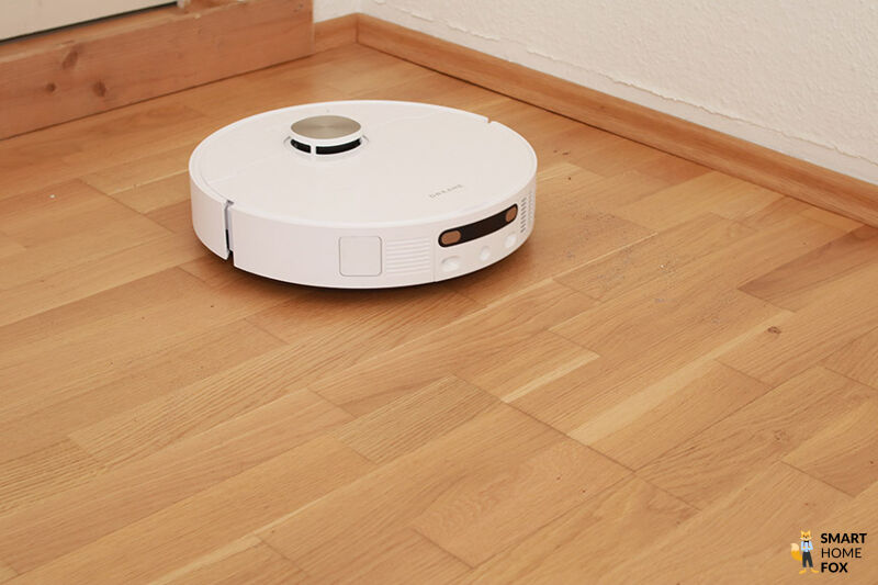 Der Dreame X40 Ultra reinigt im test Sand auf einem Laminatboden.